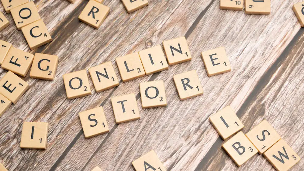 Scrabble tiles spelling 'online store' on a rustic wooden background.
