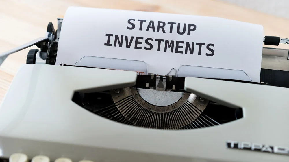 A vintage typewriter displaying a page with the words 'Startup Investments,' ideal for business and entrepreneurship themes.