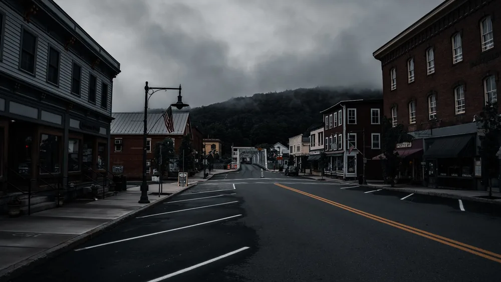 Empty town street with historic buildings and moody clouds. Perfect for travel or urban exploration themes.