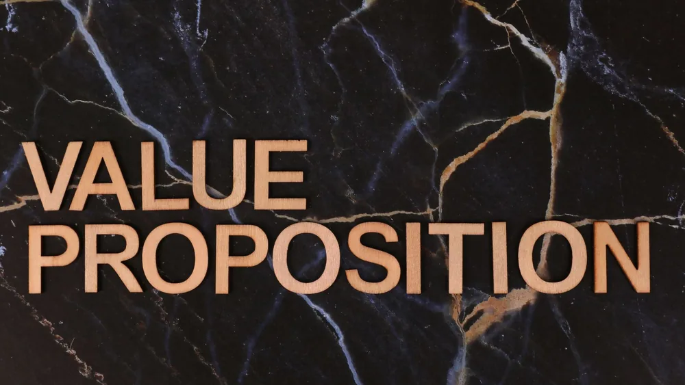 Wooden letters spelling 'Value Proposition' on a marble background, symbolizing business strategy.
