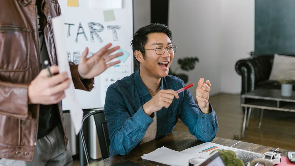 Engaged team members in a lively office meeting discussing startup ideas and innovation.