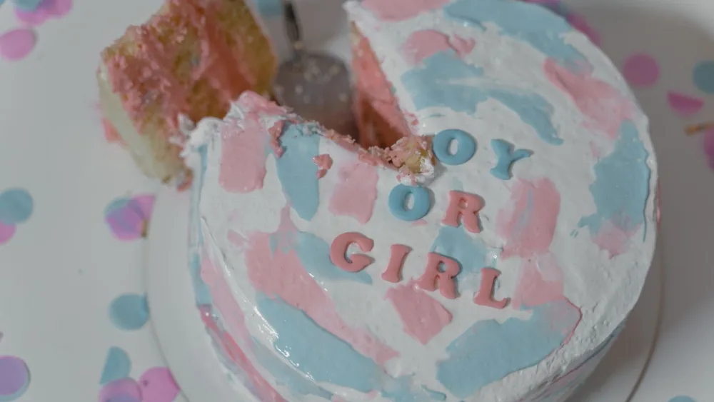 Festive gender reveal cake with pink and blue icing for a special celebration.