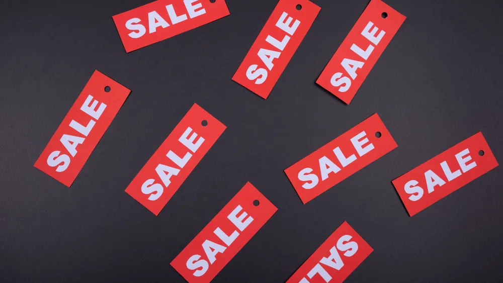 Top view of red sale tags on a black surface, perfect for marketing promotions.