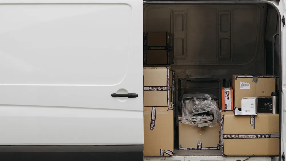 Open delivery van filled with boxes, ready for logistics and transport services.