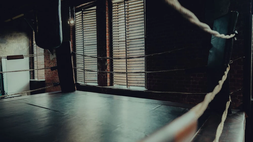 An empty boxing ring under arena lights