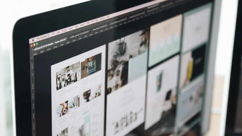 A modern computer screen displaying web design work, showcasing creative visuals in a workspace.