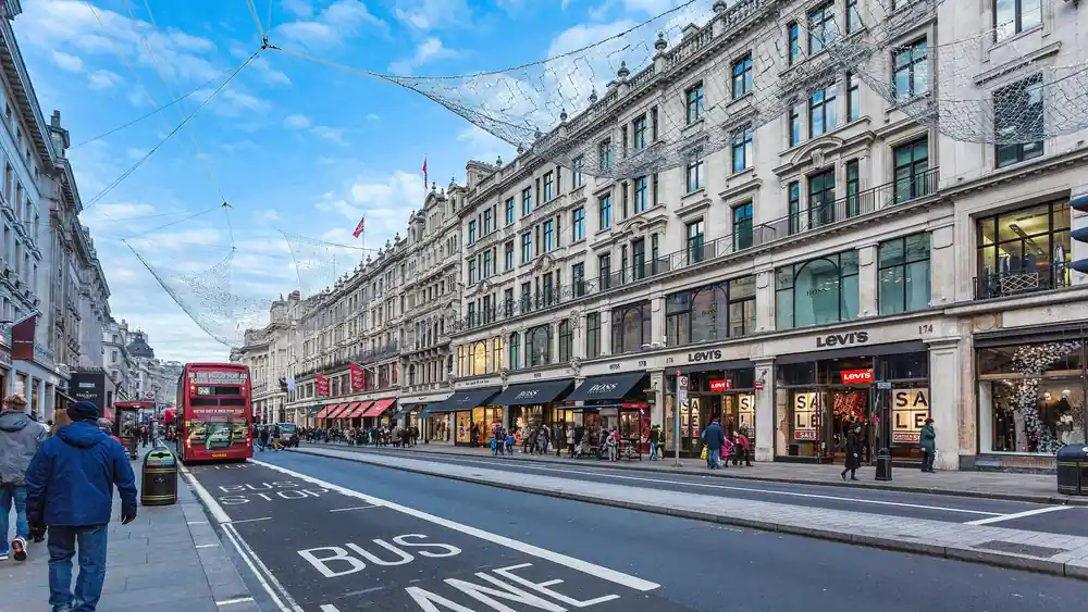 Bustling Regent Street in London with busy shoppers and iconic double-decker bus.