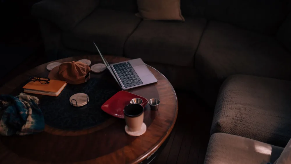 A warm, inviting living room featuring a laptop, coffee, and casual accessories.