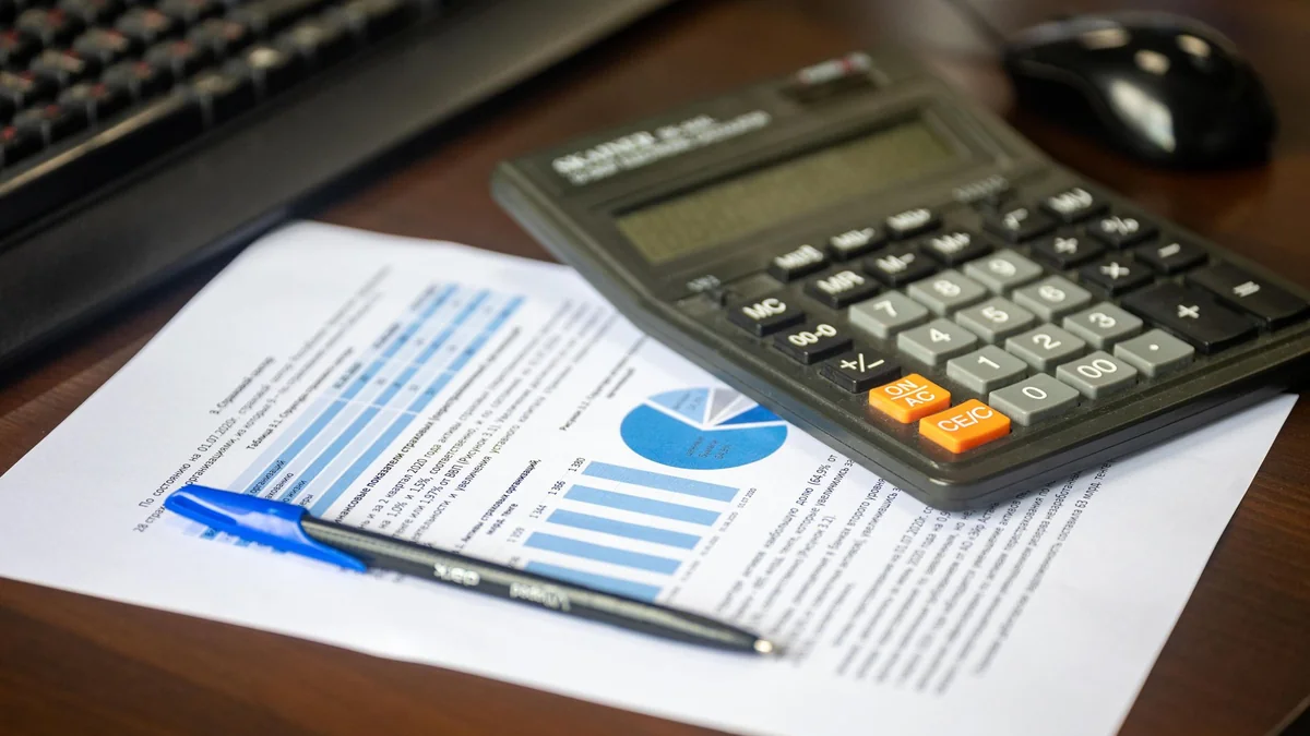 Car keys beside a calculator and finance paperwork