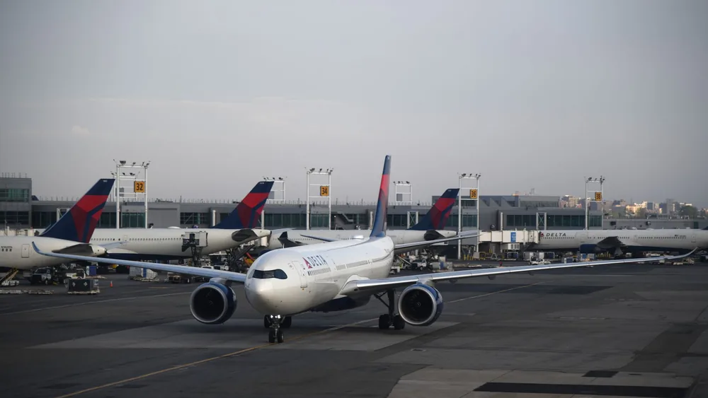 A commercial airplane on the runway at a New York airport during the day.