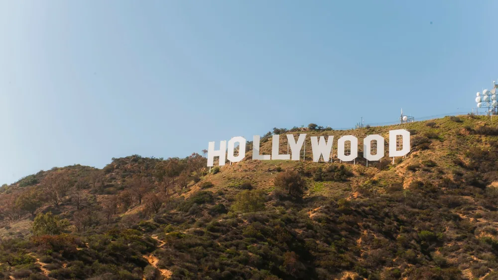 Famous Hollywood Sign on hillside under clear blue sky in Los Angeles, California.
