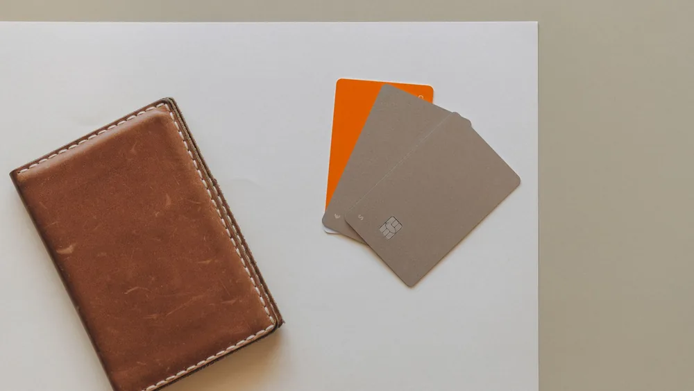 A leather wallet and credit cards on a minimalist background, ideal for financial themes.