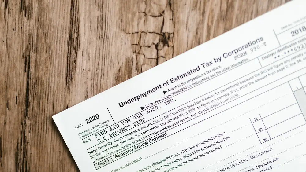 Close-up of a corporate tax form on a textured wooden surface, highlighting document details.