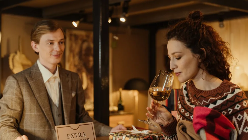 A woman enjoys a glass of wine during a sale experience at a cozy wine shop.