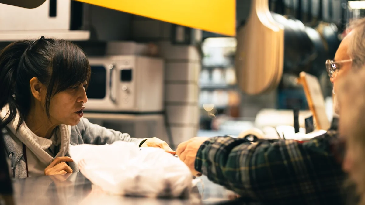 A customer raising a complaint at a shop counter