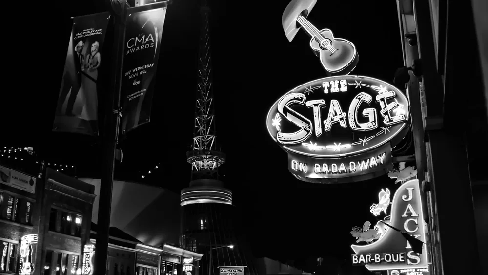 Black and white photo capturing the lively neon-lit signs of Broadway Street, Nashville at night.