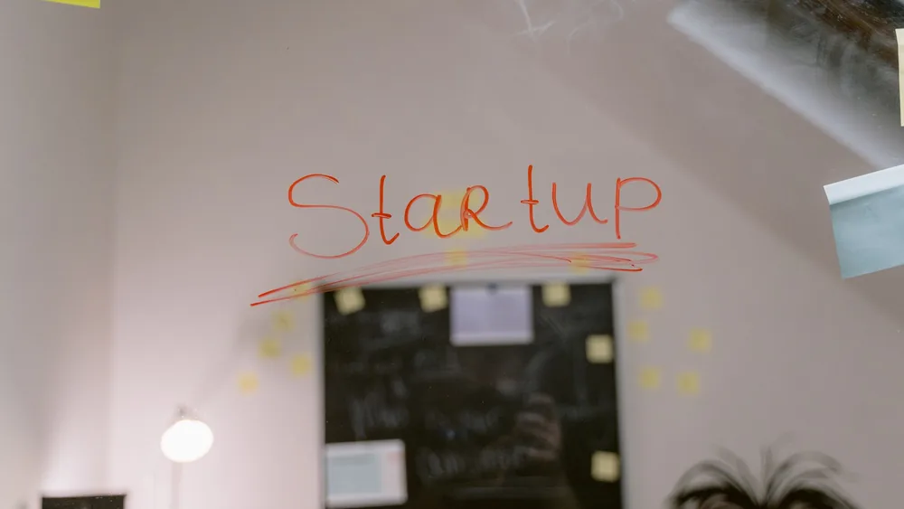 Close-up of 'Startup' written on a glass panel in an office setting.