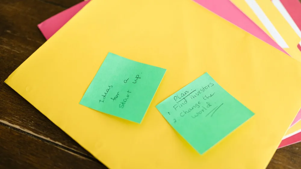 Vibrant sticky notes with startup ideas and plans placed on a desk.
