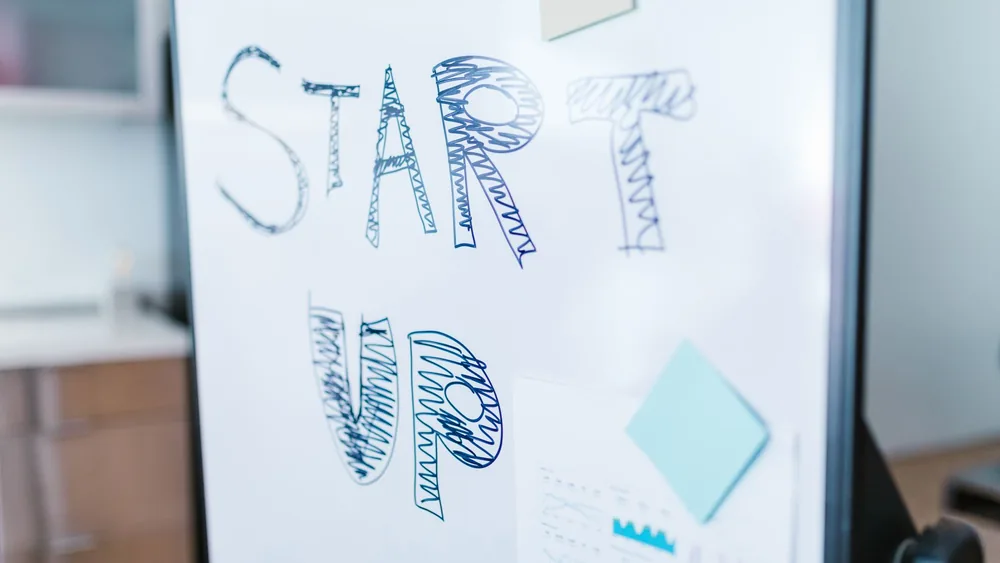 Creative startup concept handwritten on a whiteboard, symbolizing innovation in business.