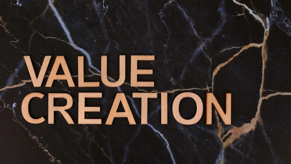Wooden letters spelling 'Value Creation' on dark marble background, perfect for business themes.