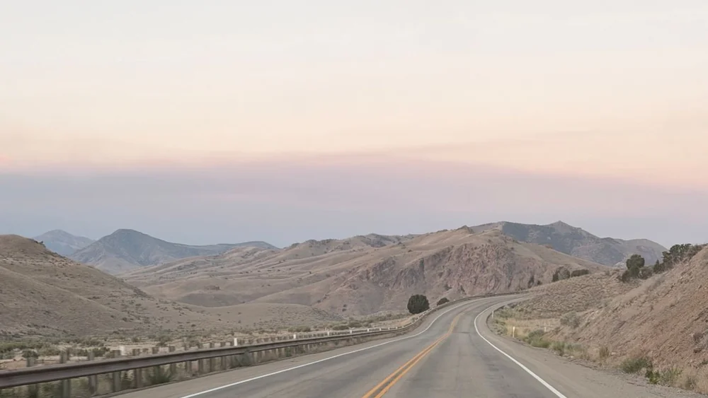 An empty American highway at dusk, the landscape the Reacher novels move through