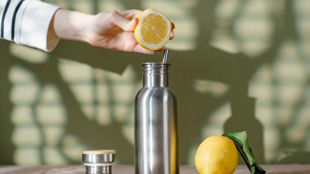 A stainless steel bottle with a lemon for an eco-friendly drink. Perfect for zero waste lifestyle.