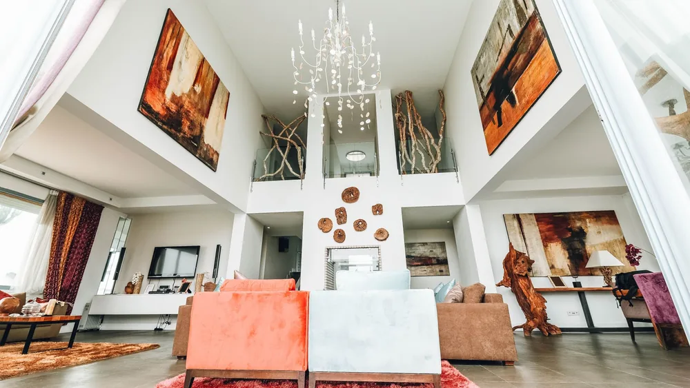 Luxurious interior with chandelier, art, and stylish furniture arrangement.