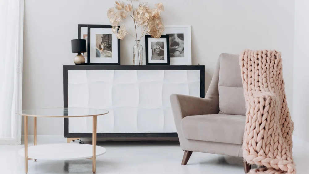 A cozy, contemporary interior setup with a beige chair, soft decor, and elegant furnishings.