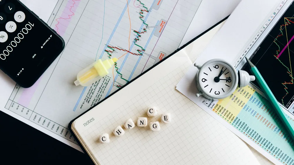 Top view of financial documents with charts, calculator, clock, and the word 'Change' in focus.