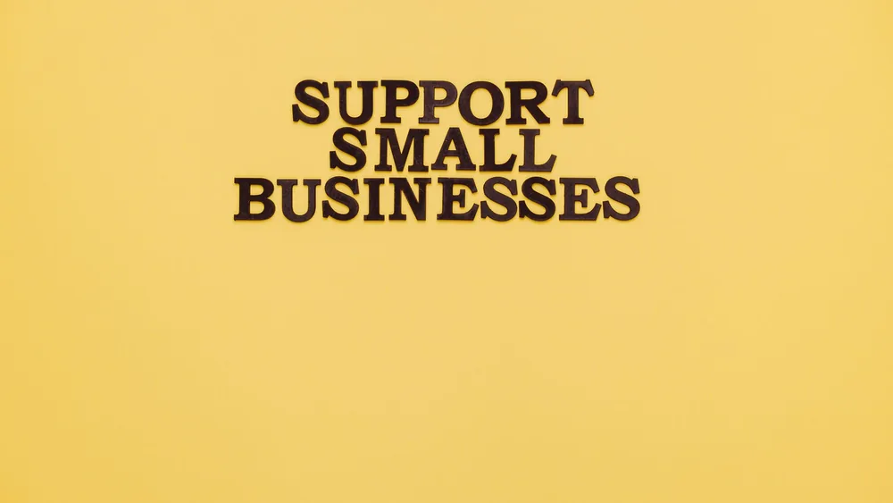 Inspirational image with 'Support Small Businesses' text on a warm yellow background.
