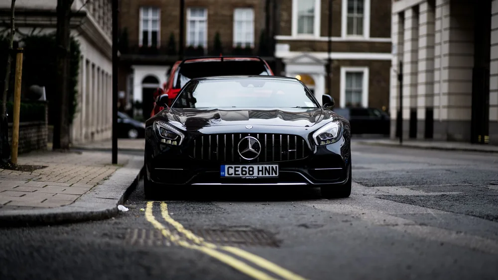 A sleek black Mercedes Benz parked on a London street, showcasing luxury and style.