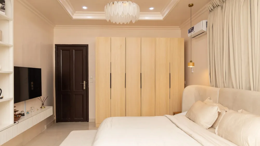 A serene and stylish modern bedroom with beige tones and soft lighting