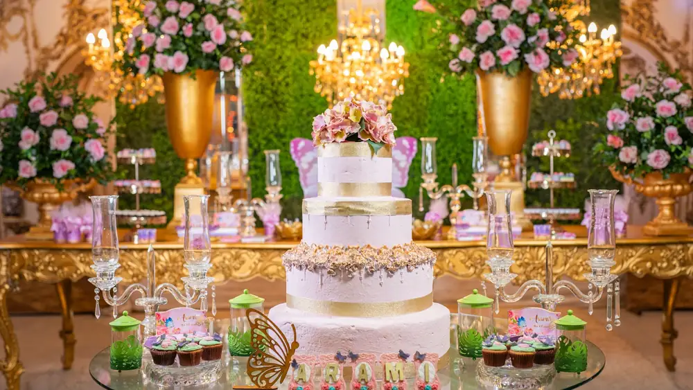 Luxurious quinceañera setup with a grand cake, florals, and upscale decor in a vibrant setting.