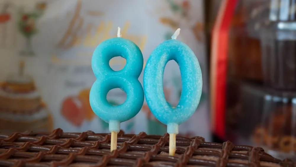 Blue number candles on an 80th birthday cake, perfect for celebratory occasions.