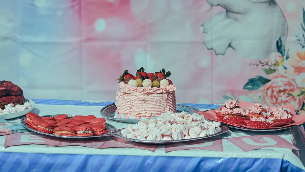 Vibrant dessert table featuring a cake with strawberries and assorted sweets, perfect for celebrations.