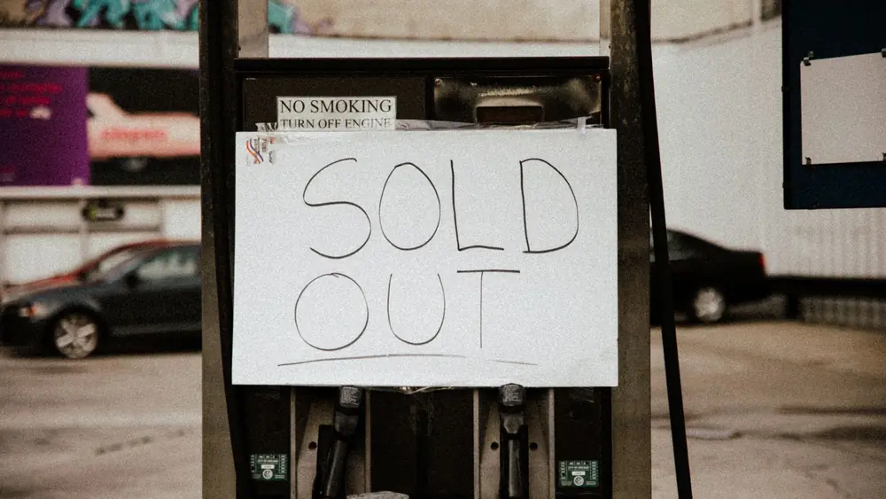 A gas pump at an urban station displaying a 'Sold Out' sign, illustrating fuel shortage.