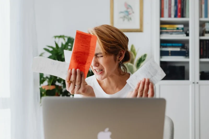 Receipts and a laptop on a desk, the raw material of digital record keeping