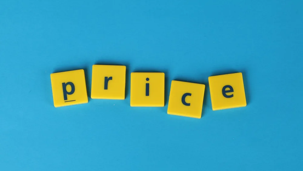Yellow letter tiles spell the word 'price' against a vibrant blue backdrop, ideal for business concepts.