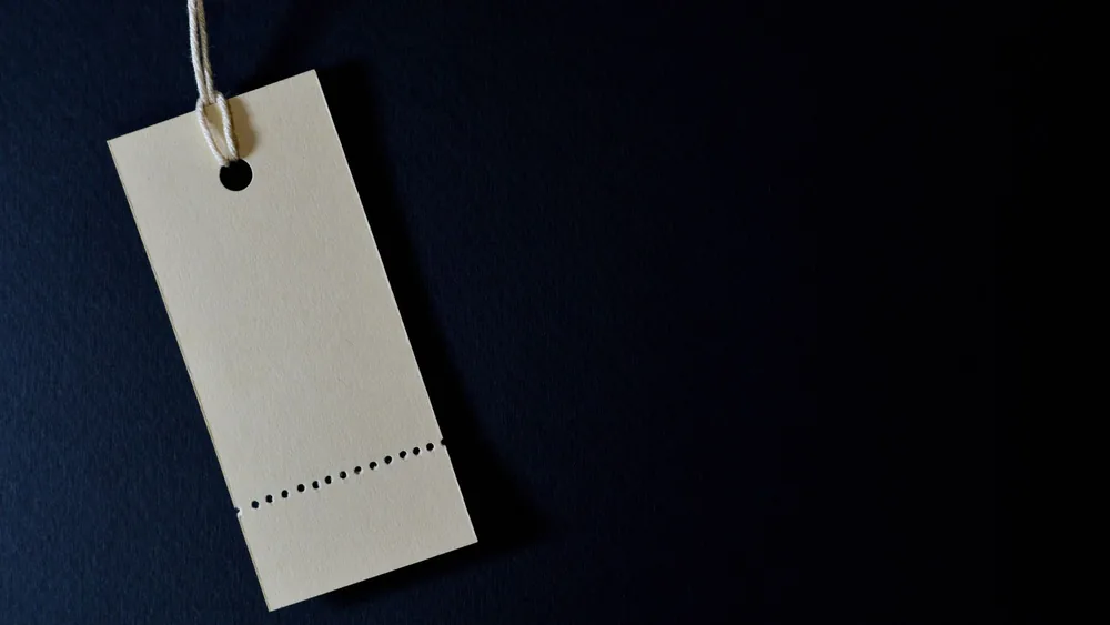 Elegant minimalist card with a string, ideal for labeling or pricing against a black background.