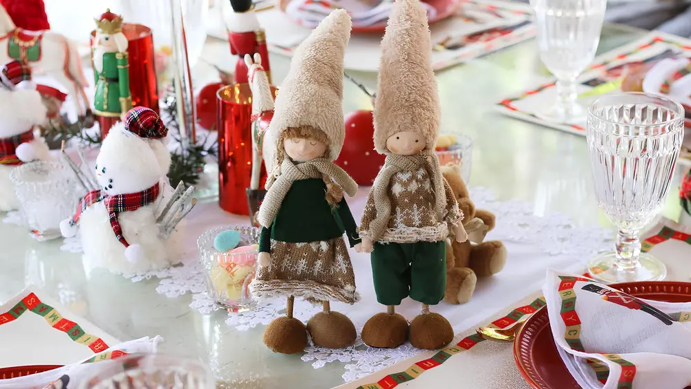 Festive holiday table with Christmas decor, featuring adorable elf figurines and plush snowmen.