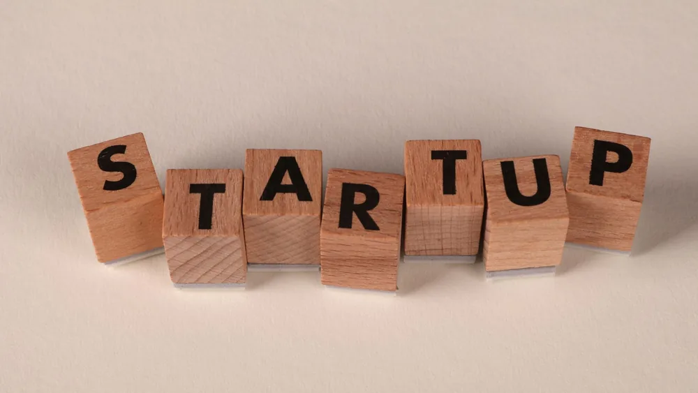 Wooden blocks forming the word 'STARTUP' on a neutral background, symbolizing new business ventures.