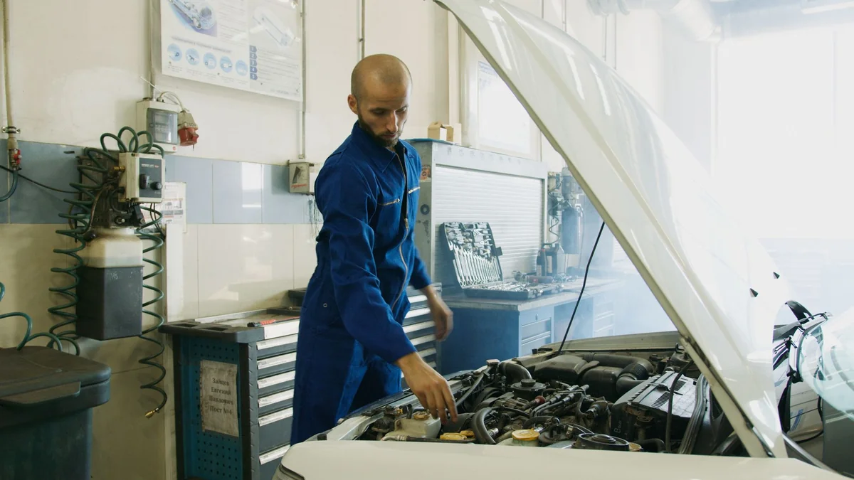 A mechanic inspecting a car engine fault