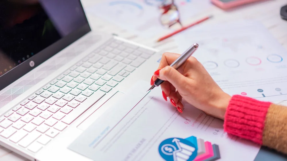 A budget being worked out on a laptop and notepad