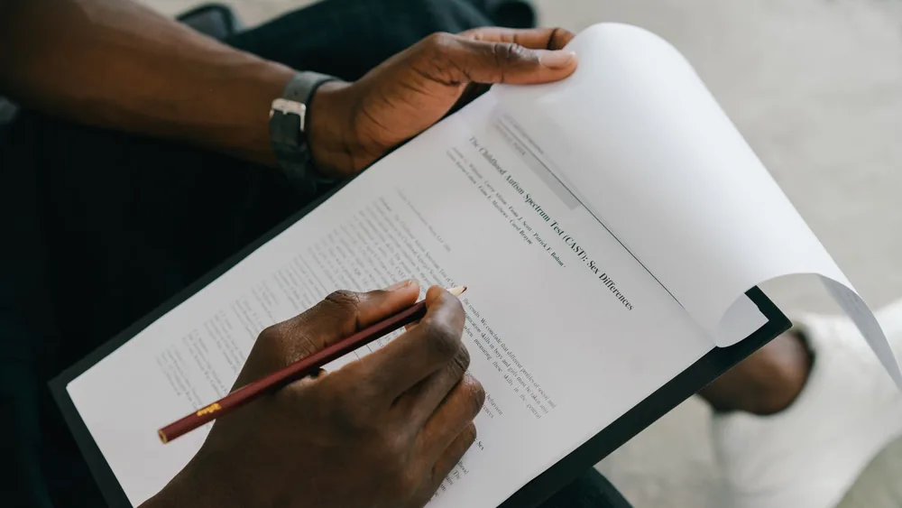 Close-up of a person writing on a psychological assessment form with a pencil.