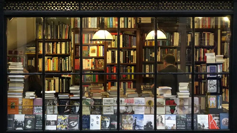 A cozy London bookstore showcasing various books through a classic window display.