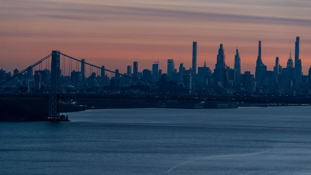 Captivating view of the NYC skyline and George Washington Bridge at sunset.