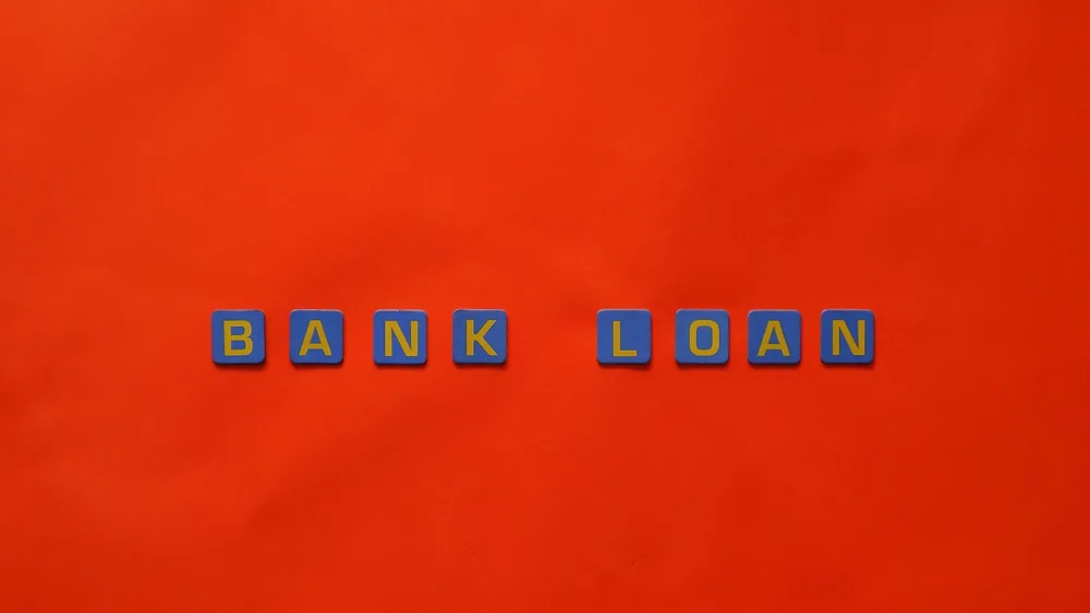 Letters forming 'Bank Loan' on a vibrant red surface, ideal for finance themes.
