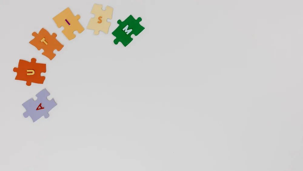 Puzzle pieces spelling autism on a white background, symbolizing autism awareness.