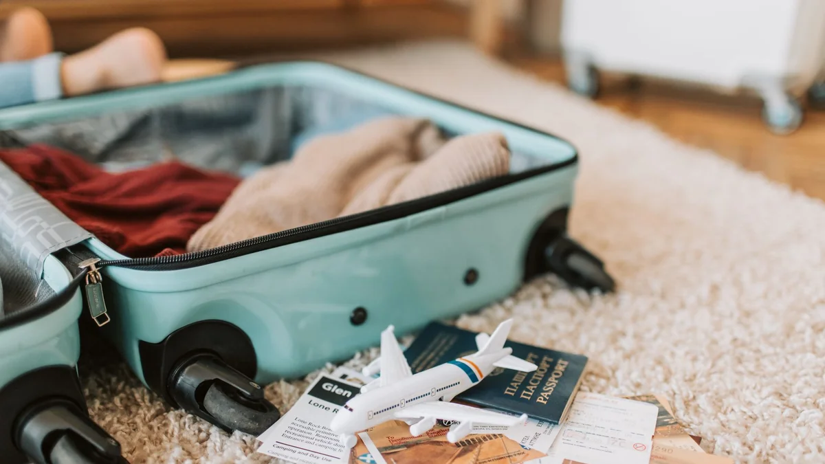 A passport and suitcase packed for a trip abroad
