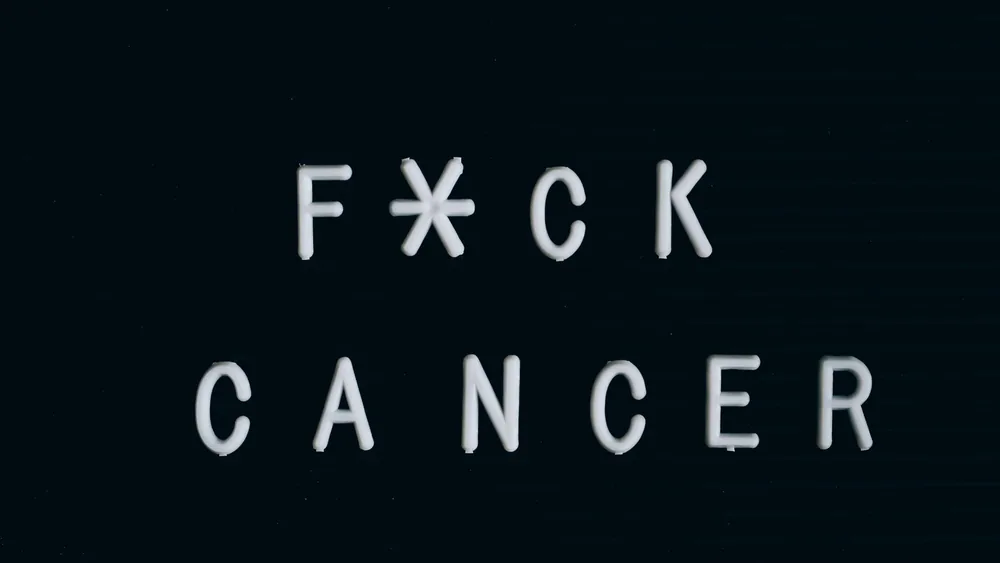 Motivational anti-cancer message on a letter board, emphasizing awareness.